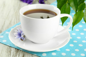 Cup of tea with chicory, on wooden table