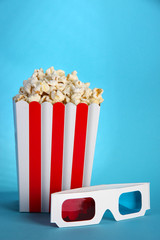 Popcorn and 3D glasses on blue background