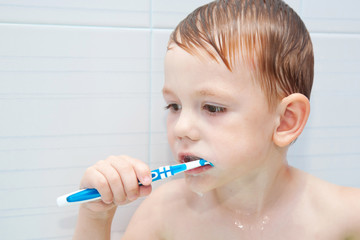Little child brushing teeth closely.