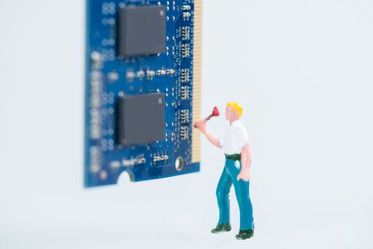 Miniature workman working on the computer RAM close up
