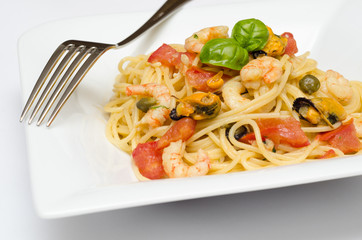 Spaghetti con frutti di mare, pomodoro e capperi