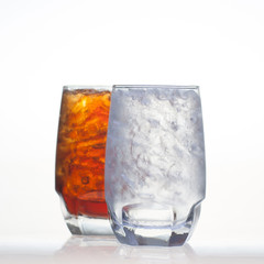 Sparkling cola drinks with water soda and ice in glass isolated