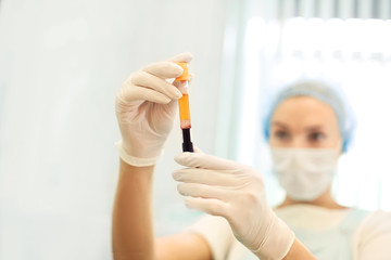 Medical doctor woman looking on test tube with blood