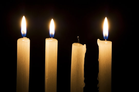 Extinguished candle among burning ones