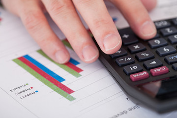 Close-up Of A Businessman Hand Analyzing Stock Charts