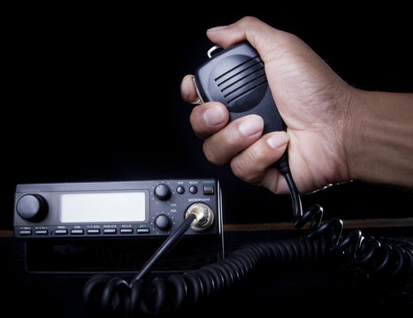 hand of Amateur radio holding speaker and press