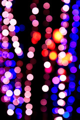Naklejka premium Defocused light bulbs at night as background
