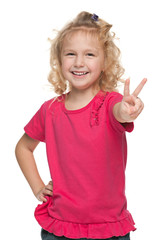 Laughing little girl shows victory sign
