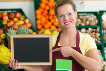 shop assistant holding sign-board in a grocery
