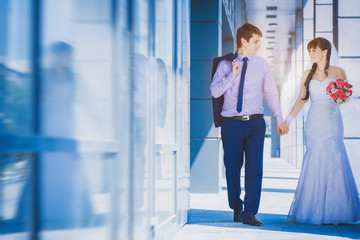 bride and groom against a blue modern building