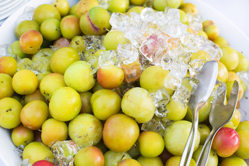 Fresh natural ripe plums with ice cubes