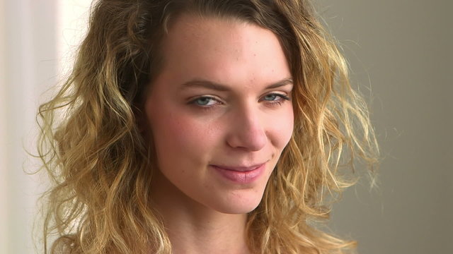Close-up of a happy blonde woman with curly hair