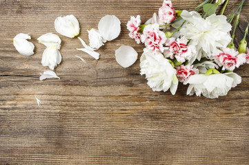 Bouquet of white peonies and pink carnations on wooden backgr