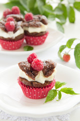 Chocolate muffins with raspberries and cream.