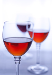Three transparent wineglasses with rose wine. White background