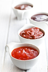 various barbecue sauces in ceramic bowls