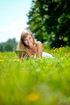 Beautiful smiling woman with tablet pc, outdoors