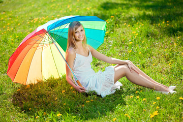 Naklejka na ściany i meble Smiling woman with a rainbow umbrella outdoors