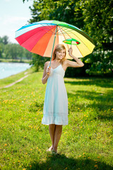 Smiling woman with a rainbow umbrella outdoors