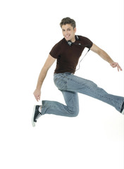 Excited young man jumping and smiling with listening music