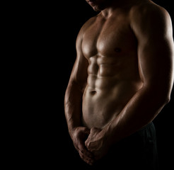 Close up of perfect male body isolated on black