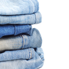 Stack of blue jeans on white background