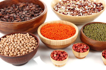 Different kinds of beans in bowls isolated on white