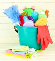 Cleaning items in bucket on  white wooden background