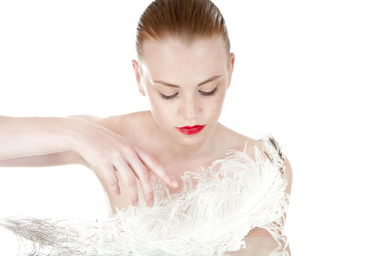 Beautiful  girl with a white feather. Spy beauty skin treatment.