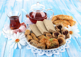 Sweet baklava on plate with tea on table