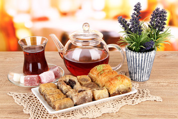 Sweet baklava on plate with tea on table in room
