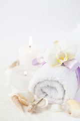 Fototapeta na wymiar Spa setting with towel, orchid and seashells