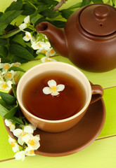 Cup of tea with jasmine, on wooden table, close-up