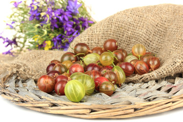 Fresh gooseberries on wicker mat close-up