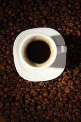Cup of coffee on coffee beans background