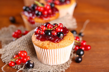 Tasty muffins with berries on wooden table