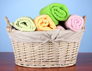 Obraz na płótnie Canvas Colorful towels in basket on color background