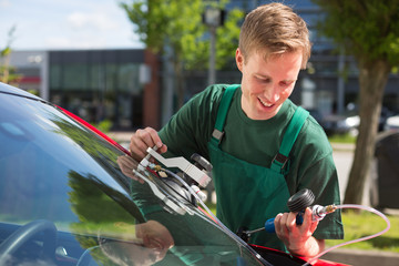 Glazier repairing windscreen after stone chipping damage