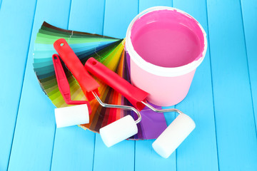 Set for painting: paint pots, paint-roller on blue wooden table
