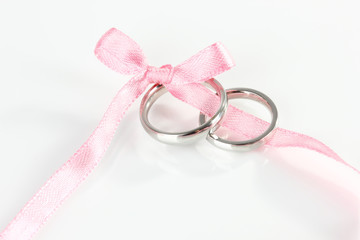 Wedding rings tied with ribbon isolated on white