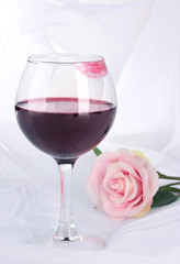 Glass of wine with lipstick imprint on white fabric background