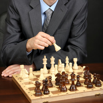 Young Business Man Playing Chess On Black Background