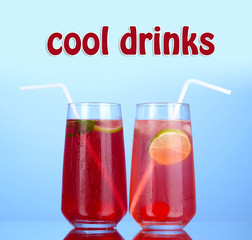 Two cherry cocktails with ice on blue background