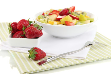 Useful fruit salad of fresh fruits and berries in bowl isolated