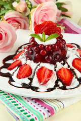 Tasty jelly dessert with fresh berries, on pink roses