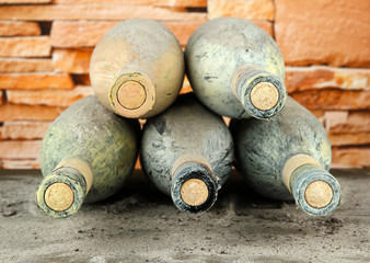 Old bottles of wine, on bricks background