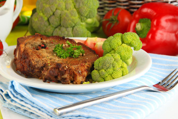 Piece of fried meat on plate on wooden table close-up
