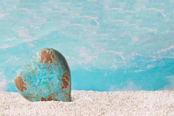 Fototapeta na wymiar Samotne serca w kolorze turkusowym na plaży - morski dekoracji
