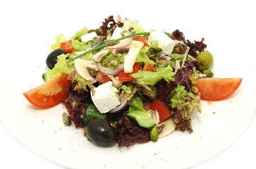 Greek salad on white plate in a restaurant