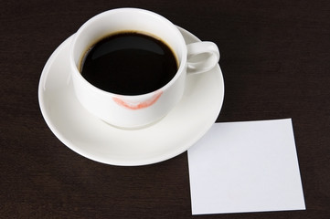 Cup of coffee with lipstick mark and blank paper note for text